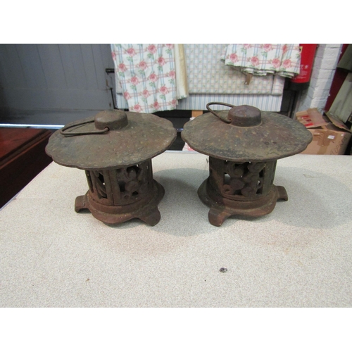 1196 - A pair of cast iron Pagoda form tea light holders, approximately 12cm high