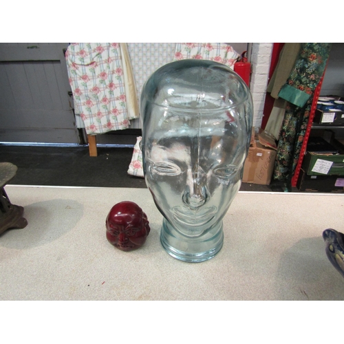 1198 - A glass head, 29cm high, together with a buddha head (2)