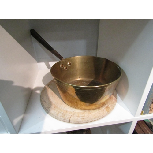 1412 - A heavy brass saucepan with copper rivets 23cm in diameter and a bread board (a/f)