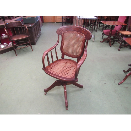 4002 - A circa 1900 oak and mahogany cane seat and backrest revolving office chair with walnut decoration t... 