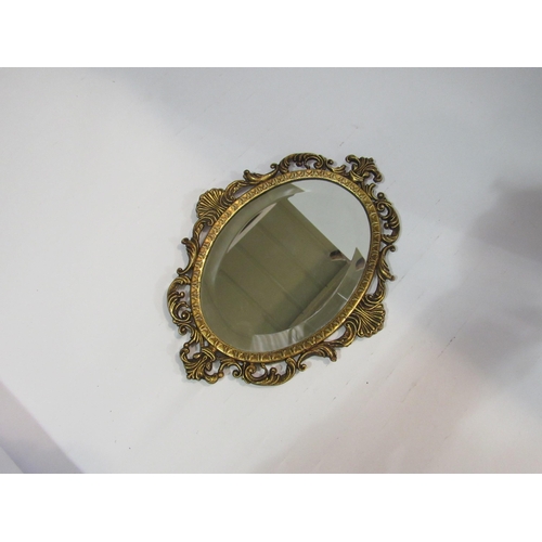 4125 - An Italian gilt metal oval bevel edge mirror with ornate frame, 24cm high x 18cm wide total