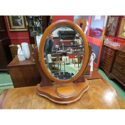 4218 - A walnut oval dressing table bevel edged mirror with lidded compartment to base on bun feet