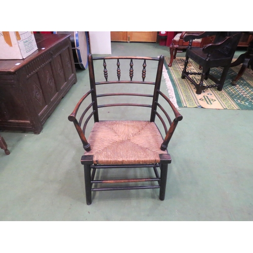 4221 - A Morris & Co. Arts & Crafts ebonised rush seated armchair in the classic Sussex style designed by P... 