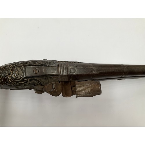 4355 - A late 18th Century flintlock pistol with all over scrolled foliate carving, part of mechanism missi... 