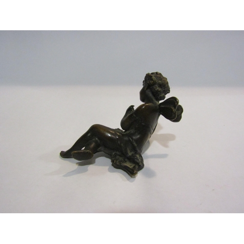 4327 - A bronze figure of a recumbent cherub, 5cm tall, 7cm long  (R)  £50