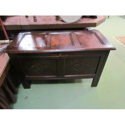 4003 - Circa 1760 a pegged oak three panel lid coffer with carved front on stile feet (with working lock an... 