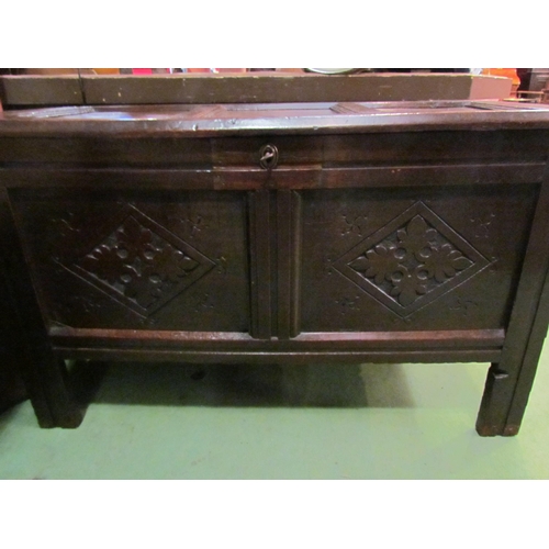 4003 - Circa 1760 a pegged oak three panel lid coffer with carved front on stile feet (with working lock an... 