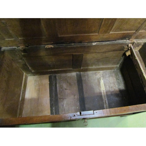 4003 - Circa 1760 a pegged oak three panel lid coffer with carved front on stile feet (with working lock an... 