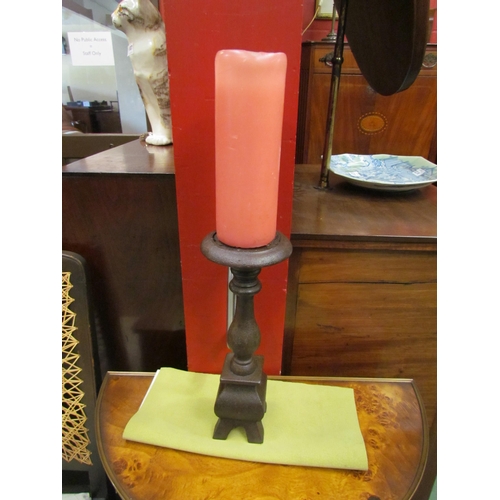 4110 - An early Victorian cast iron candlestick holder with candle, holder 30cm high