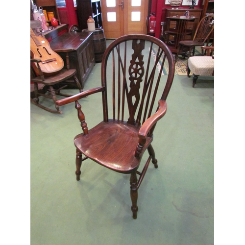 4120 - A 19th Century elm and ash hoop back Windsor armchair with central wheel splat the saddle seat over ... 