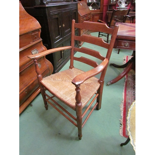 4188 - An Arts & Crafts Cotswold school oak ladder back armchair with rush seat and turned fore legs united... 