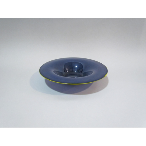 4293 - GILLIES JONES: A dark blue glass bowl with yellow rim, 19cm diameter