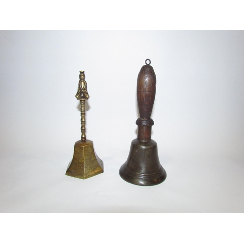 4311 - Two brass handbells, one of Oriental form with figural finial