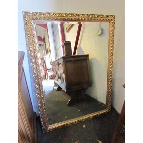 1006 - A large modern gilt rectangular hall mirror with acanthus scroll detail, bevelled glass. 89cm x 120c... 