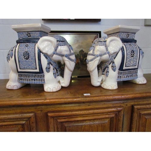 1008 - A pair of elephant form blue and white jardiniere stands, 42cm high