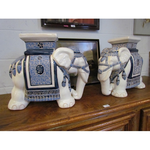 1008 - A pair of elephant form blue and white jardiniere stands, 42cm high