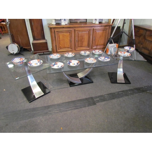 1014 - A set of three designer occasional tables, the bevel edge tops on tapering stainless steel columns, ... 