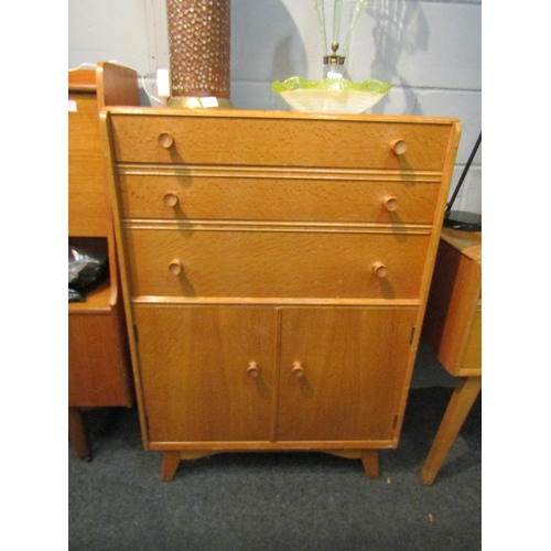 1033 - A 1960's Austinsuite light oak cupboard, three drawers over two cupboard doors, splayed legs, 107cm ... 