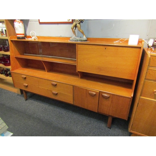 1036 - A retro 1960’s teak sideboard with glazed display section, drop-flap, four drawers and two cupboard ... 