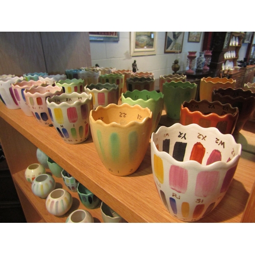 1043 - A quantity of studio pottery pots decorated in numbered glazes in different colours/shades, some a/f... 