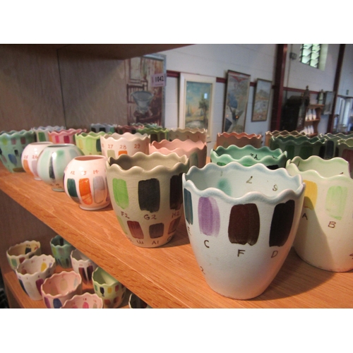 1043 - A quantity of studio pottery pots decorated in numbered glazes in different colours/shades, some a/f... 