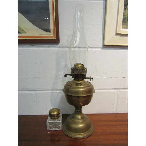 1057 - A brass based oil lamp and a glass inkwell with brass lid