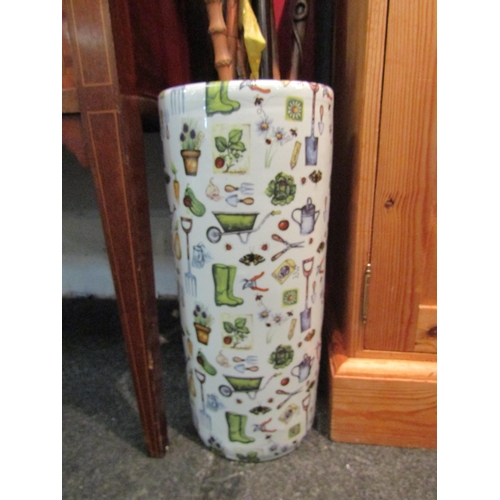 1073 - A china cylindrical umbrella and stick stand with all over design of gardening tools and plants, 44c... 