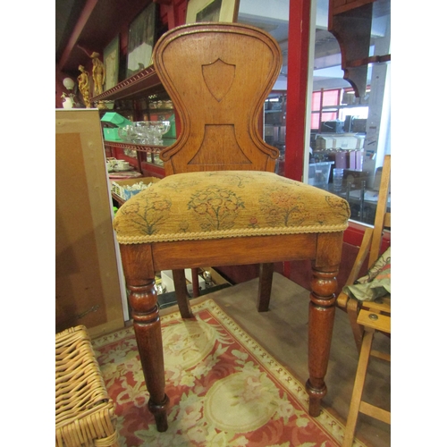 4005 - In the manner of Gillows of Lancaster, a pair of mid Victorian oak hall chairs, the spoon shape back... 