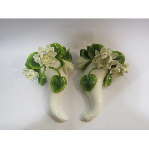 4208 - A pair of Moore T. Goode Co porcelain wall pockets with applied floral design, 25cm high