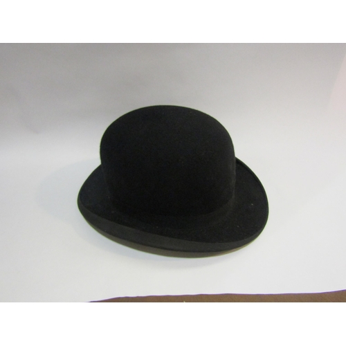 4216 - A bygone tin hat box containing a black bowler hat