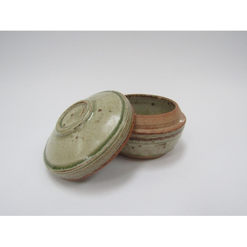 7104 - RICHARD BATTERHAM (1936-2021): A studio pottery stoneware lidded pot in green and brown ash glaze, 1... 