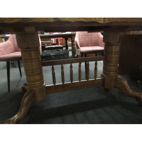 1076 - A modern oak extending dining table with two extra leaves, carved frieze with spindle base and ball ... 