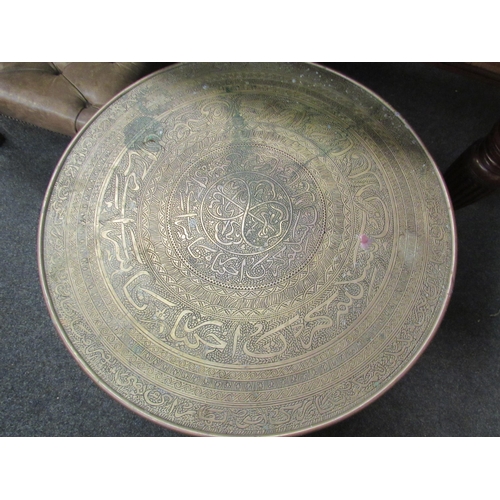 1098 - An Eastern folding table with circular brass dish of Islamic influence