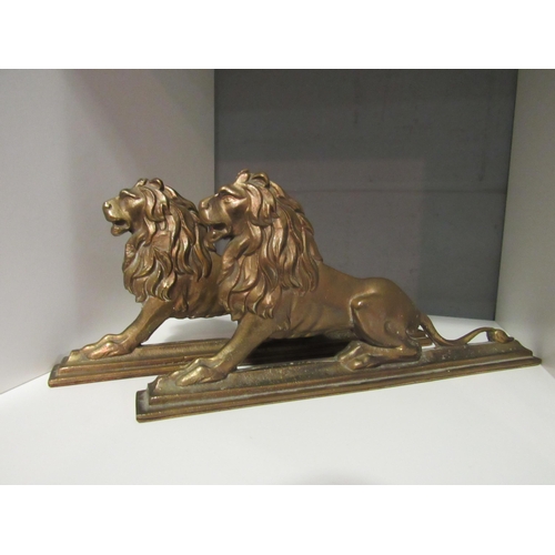 1234 - A pair of cast brass lions, each approximately 29cm long