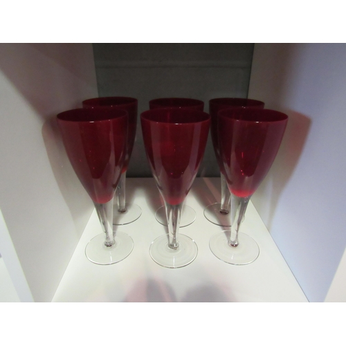 1239 - A set of six ruby glass wine glasses on clear stems