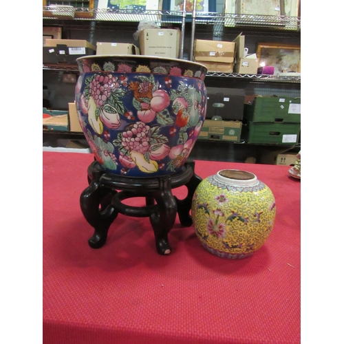 1454 - An Oriental jardiniere with goldfish decoration internally on stand and a ginger jar (2)