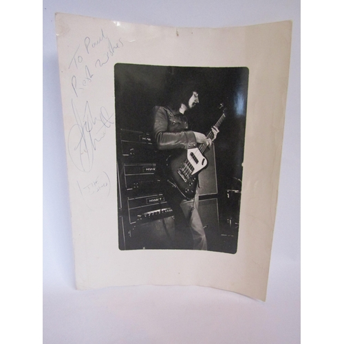 8132 - THE WHO: A black and white photograph on John Entwistle on stage, signed in blue biro 