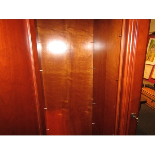 1041 - A Victorian style cherry wood wardrobe, the central mirrored door flanked by twin panelled doors, ov... 