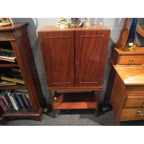 1069 - A late Victorian mahogany cabinet, the two doors opening to reveal shelf space with under-tier, on s... 