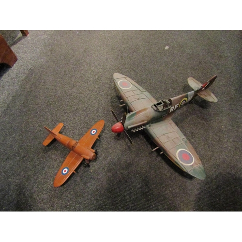 1077 - A tinplate model of a spitfire fighter aircraft together with a wooden stylised model on stand (2)