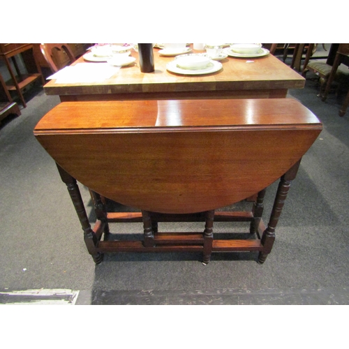 1085 - A 19th Century mahogany gateleg dining table, on ring-turned supports