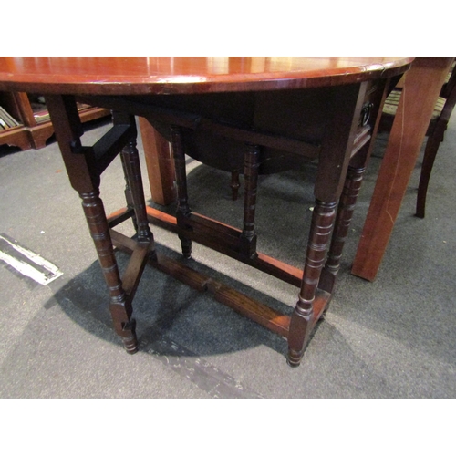 1085 - A 19th Century mahogany gateleg dining table, on ring-turned supports