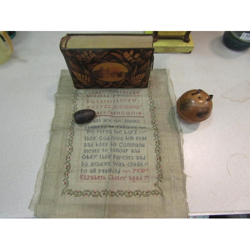 1454 - A Mauchline Ware string ball, a similar photograph album, an unframed sampler and a treen nutmeg gra... 