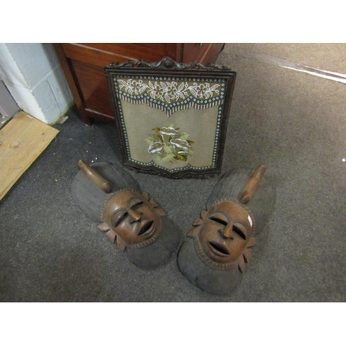 1430 - Two ethnic carved wooden masks and a beadwork panel in a carved ornate frame. Masks, 52cm high, bead... 