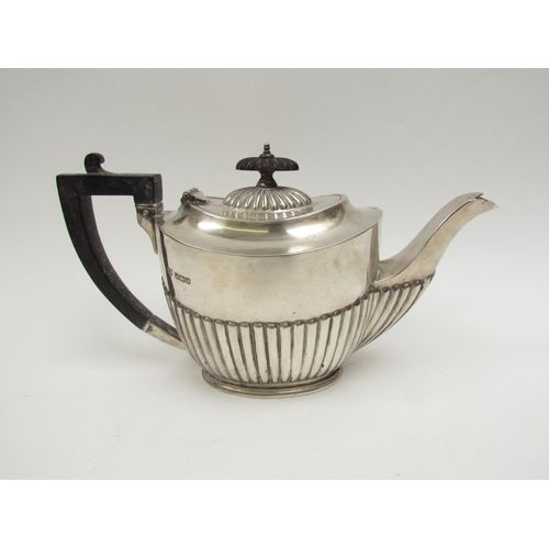 5022 - A Fredrick Wilson & Co., silver teapot with melon fluting, ebony treen knop and handle, Sheffield 19... 