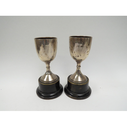 5042 - A pair of James Walter Tiptaft silver trophies, Birmingham 1933, dented and on restored, 12.5cm tall... 