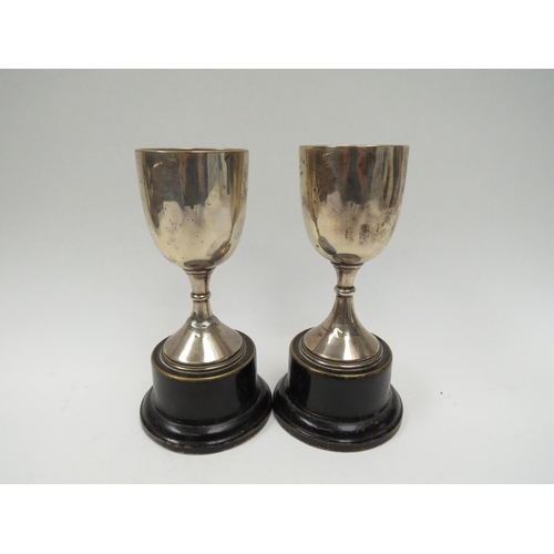 5042 - A pair of James Walter Tiptaft silver trophies, Birmingham 1933, dented and on restored, 12.5cm tall... 