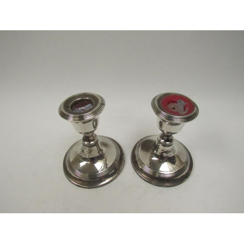 5063 - A pair of William Aitken silver candlesticks with reeded band detail, Birmingham 1919, weighted base... 