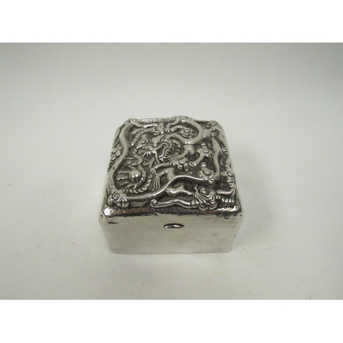 5072 - A Chinese export silver lidded box with high relief decoration of Dragon chasing flaming pearl, char... 