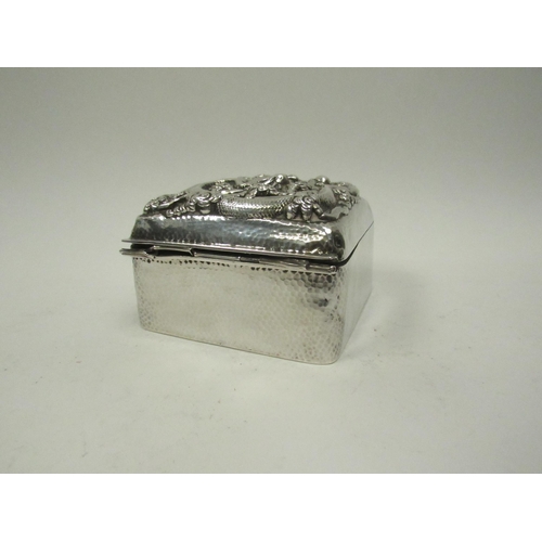 5072 - A Chinese export silver lidded box with high relief decoration of Dragon chasing flaming pearl, char... 